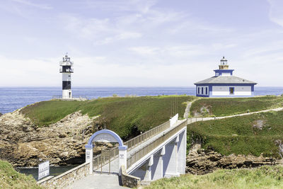 Lighthouse by sea against sky