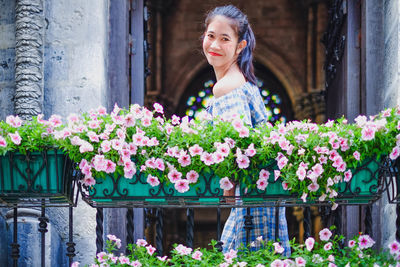 Portrait of smiling woman standing in balcony