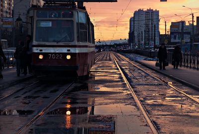 Railroad tracks in city against sky
