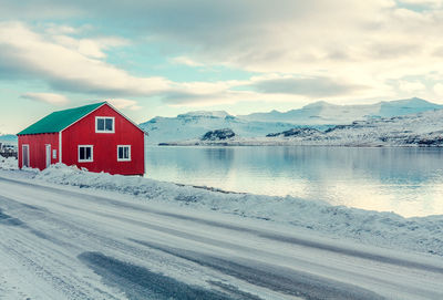 Red cabin on snowy sea coast landscape photo