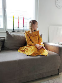 Woman sitting on sofa at home