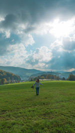 Woman standing on field against sky