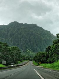 Road amidst trees against sky