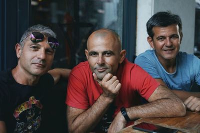 Portrait of male friends sitting at table