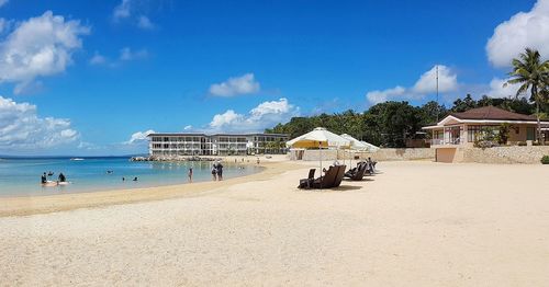 Panoramic view of people on beach against sky