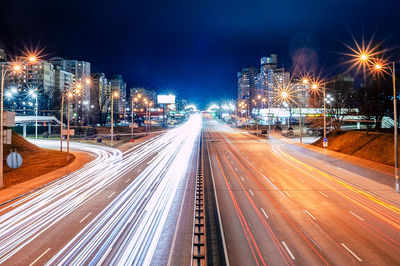 Night view of the big highway and the night city with bright multi-colored lights from cars