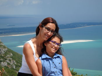 Portrait of smiling young woman against sea