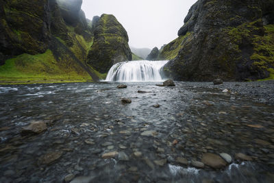 Water flowing through rocks against mountain