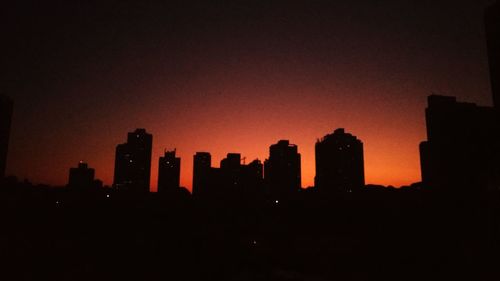 Silhouette buildings against sky during sunset