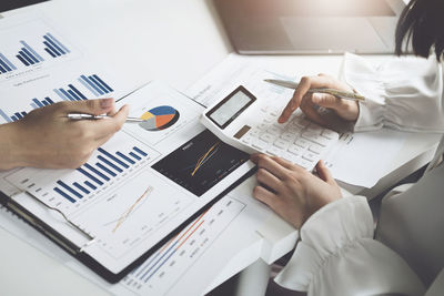 Midsection of business colleagues working on table