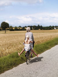 Grandmother cycling with granddaughter