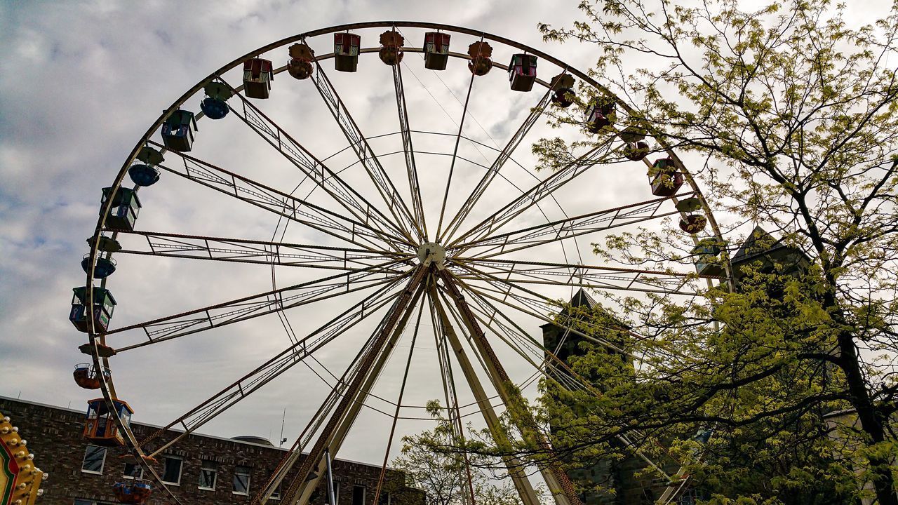 LOW ANGLE VIEW OF FERRIS WHEEL AGAINST TREES