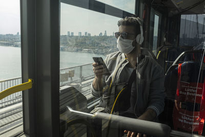 Man wearing mask while traveling in train