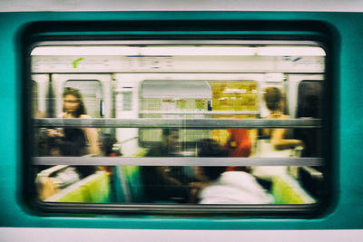 Reflection of people on train window