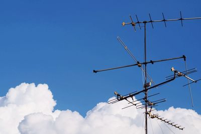 Low angle view of antenna against blue sky