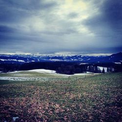 Scenic view of snow covered mountains against cloudy sky