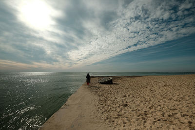 Rear view of man on beach against sky