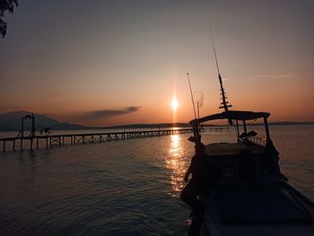 Silhouette sailboat on sea against sky during sunset