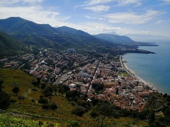 High angle view of town by sea against sky