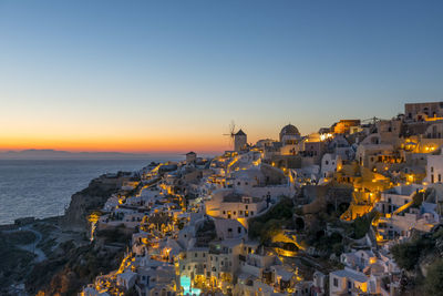 High angle view of townscape by sea against sky during sunset