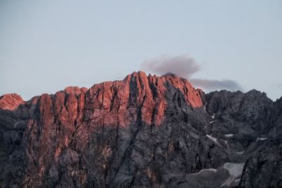 Rock formations on mountain against sunset sky