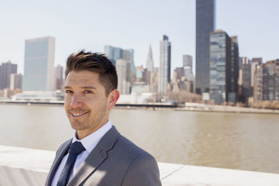 Portrait of a young businessman on a rooftop overlooking the city