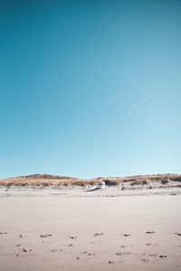 Scenic view of beach against clear blue sky