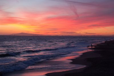 Beach against cloudy sky at dusk