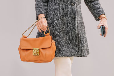 Midsection of woman standing against white background