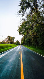 Road amidst trees against clear sky
