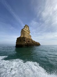 Rock formation in sea against sky