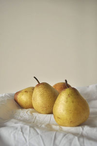 Close-up of pears on table against white background