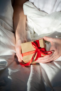 Girl unpacks a small gift in bed