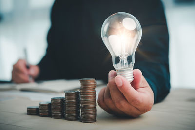 Close-up of hand holding light bulb