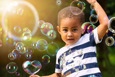 Portrait of cute boy with bubbles outdoors
