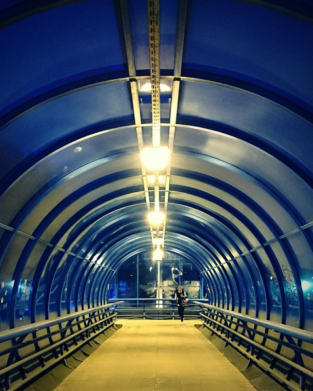 indoors, ceiling, the way forward, built structure, architecture, illuminated, diminishing perspective, lighting equipment, arch, vanishing point, in a row, tunnel, incidental people, empty, corridor, transportation, railing, modern, tiled floor, subway