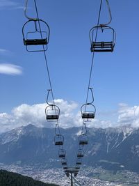 Low angle view of overhead cable car against sky