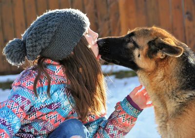 Close-up of hands holding dog during winter