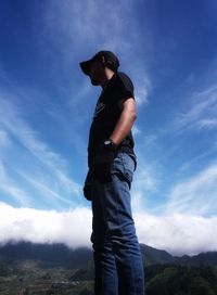 Low angle view of man standing on field against sky