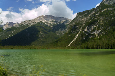 Scenic view of lake by mountains against sky