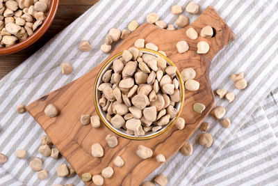 Cicerchia or indian pea on a ceramic bowl with napkin on natural wooden background, gluten free food