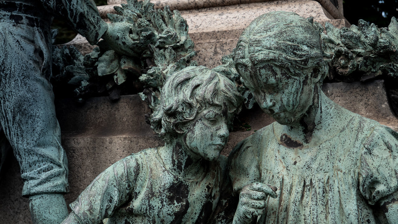 CLOSE-UP OF OLD STATUE AGAINST WALL