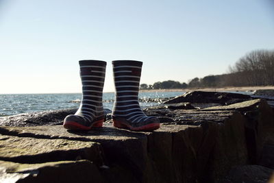 Low section of man relaxing on rock