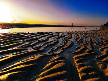 Aerial view of beach against sky during sunset
