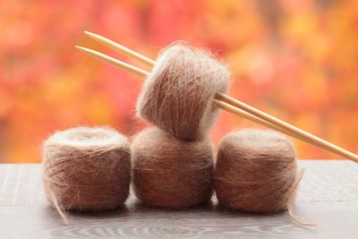 Close-up of thread and knitting needle on table