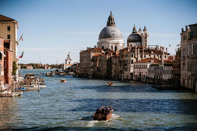 Buildings by river against built structures