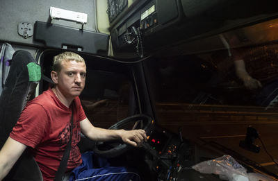 Portrait of man sitting in bus at night