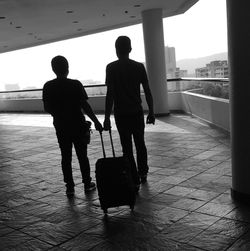 Silhouette of people standing with luggage