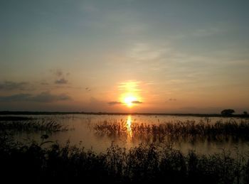 Scenic view of lake against sky during sunset