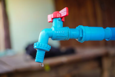 Close-up of faucet against blue water pipe